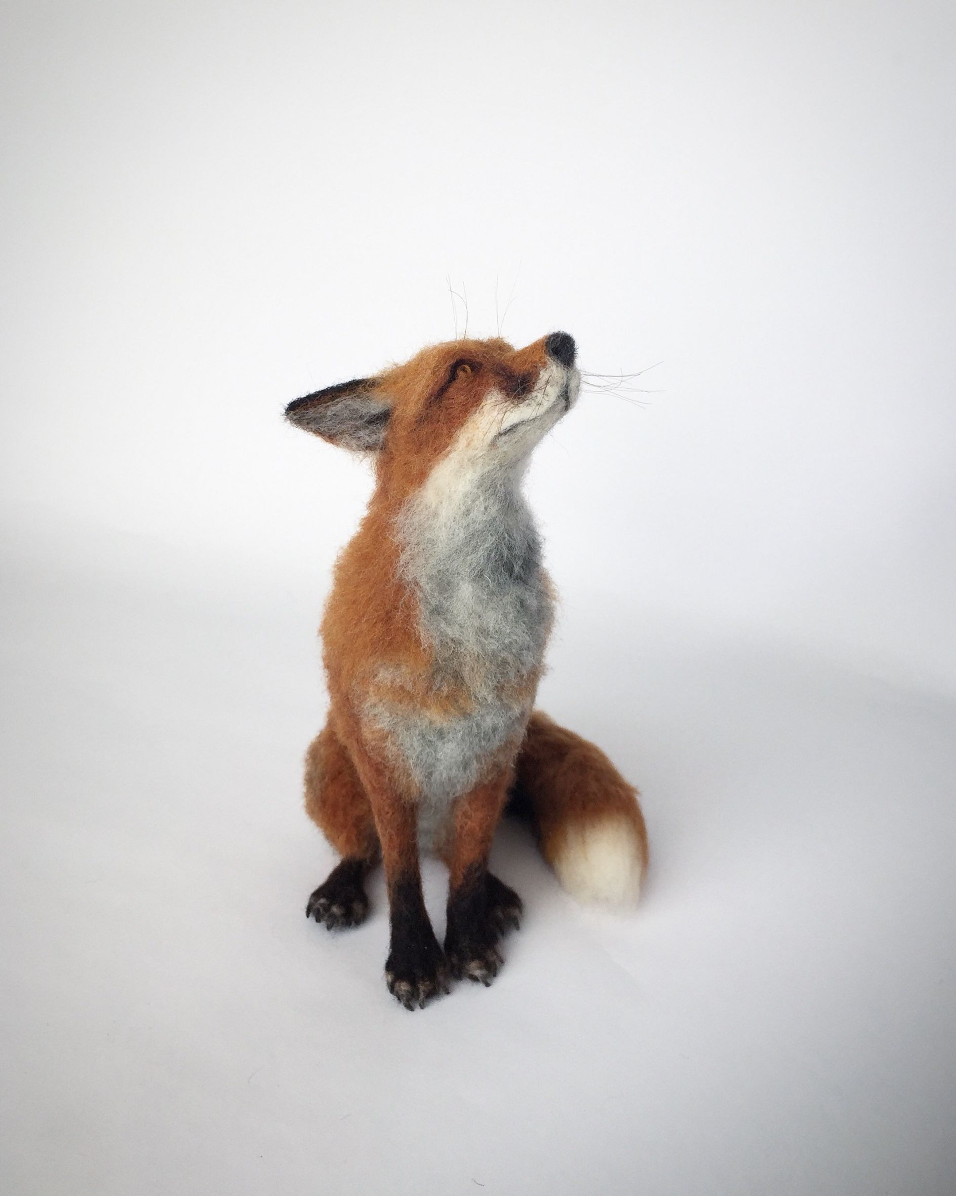 Needle felted sculptures of foxes and dogs that fit into the palm of ...